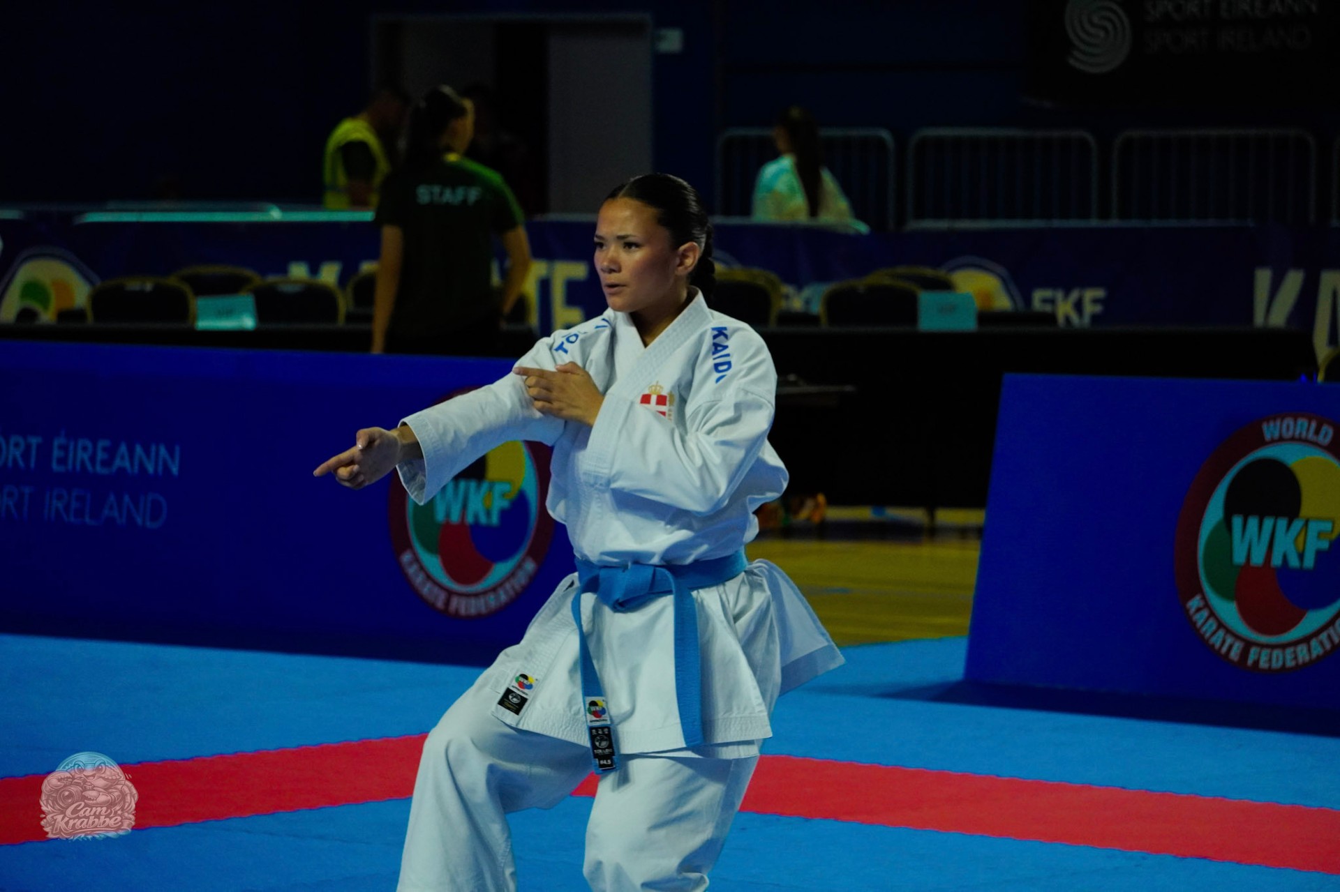 Freja Chung Jepsen performing kata in a blue belt and Denmark karate gi on the mat at a WKF karate competition