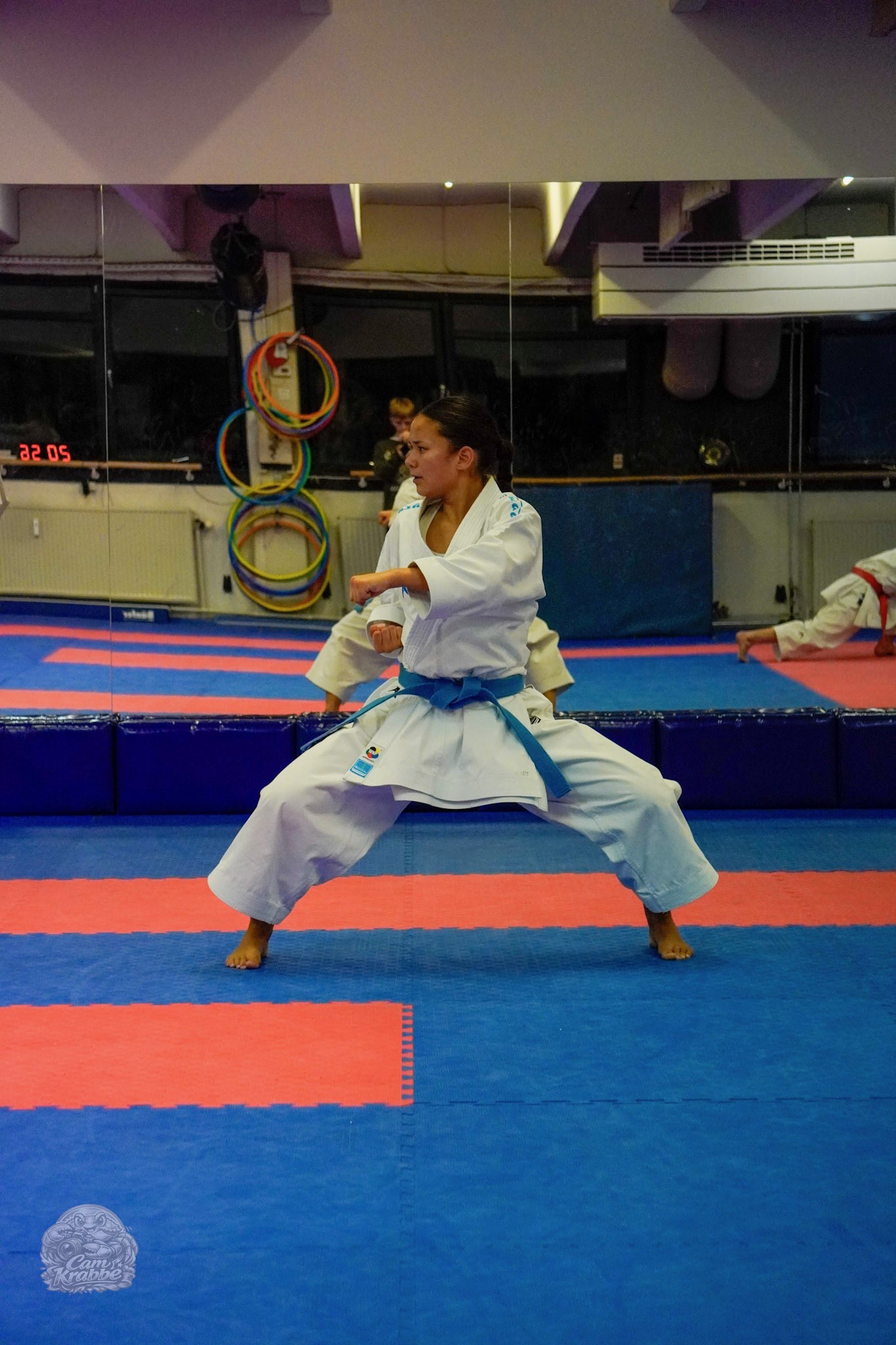 Freja Chung Jepsen in a wide karate stance during training in front of the dojo mirrors
