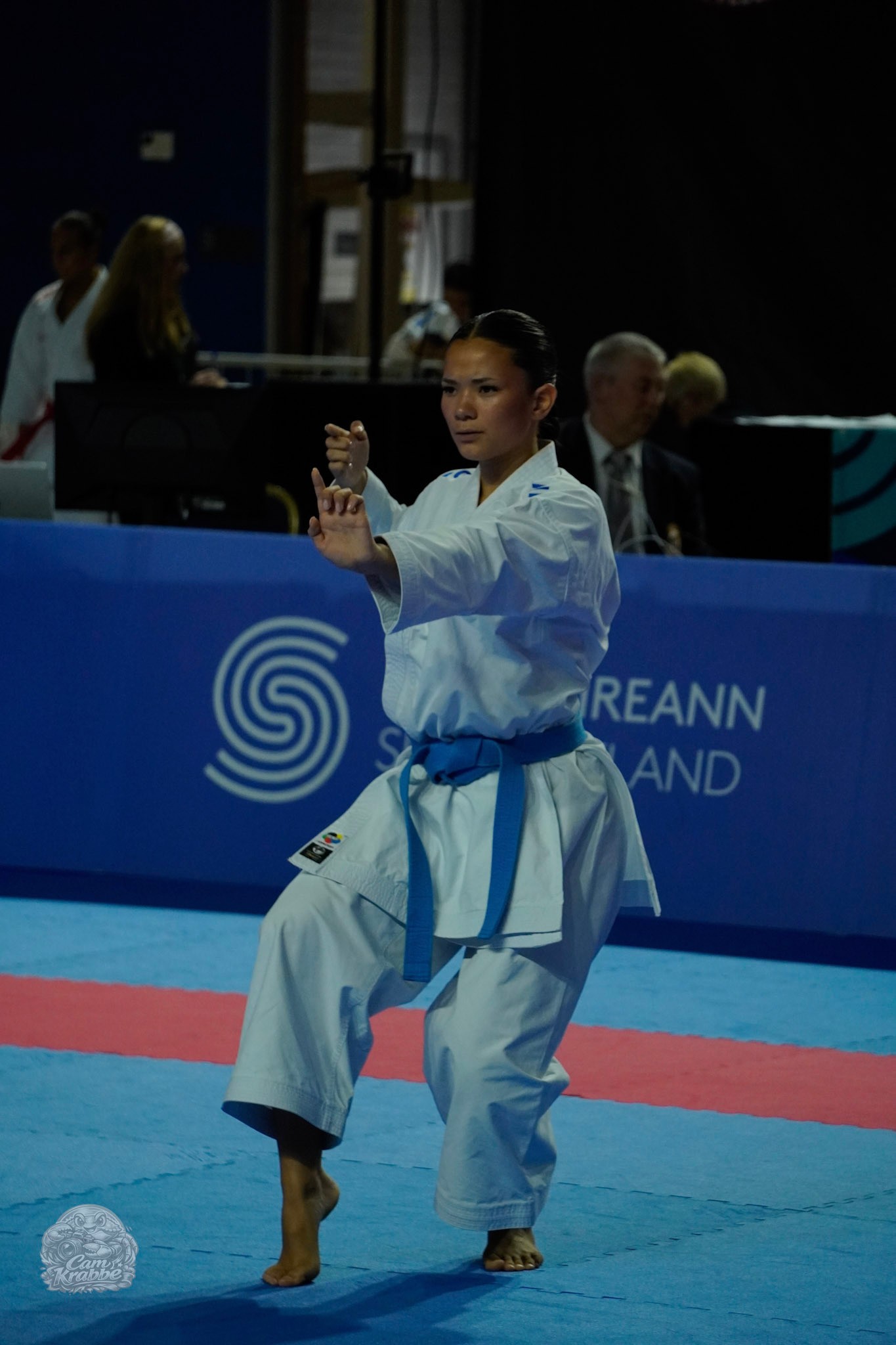 Freja Chung Jepsen in a blue belt performing kata with focused expression on the mat at an international karate competition