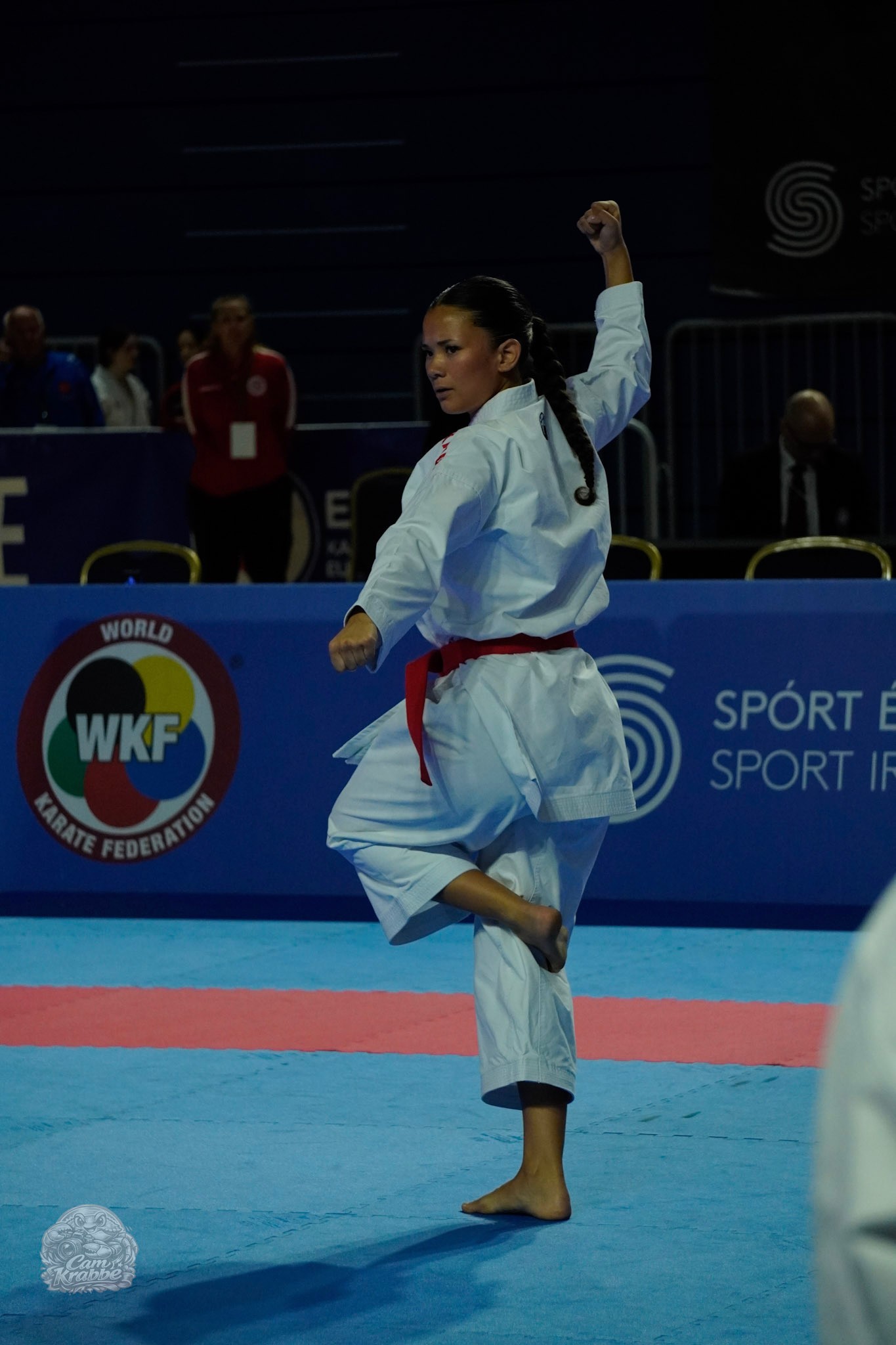 Freja Chung Jepsen balancing on one leg with a raised fist during kata at a WKF karate competition